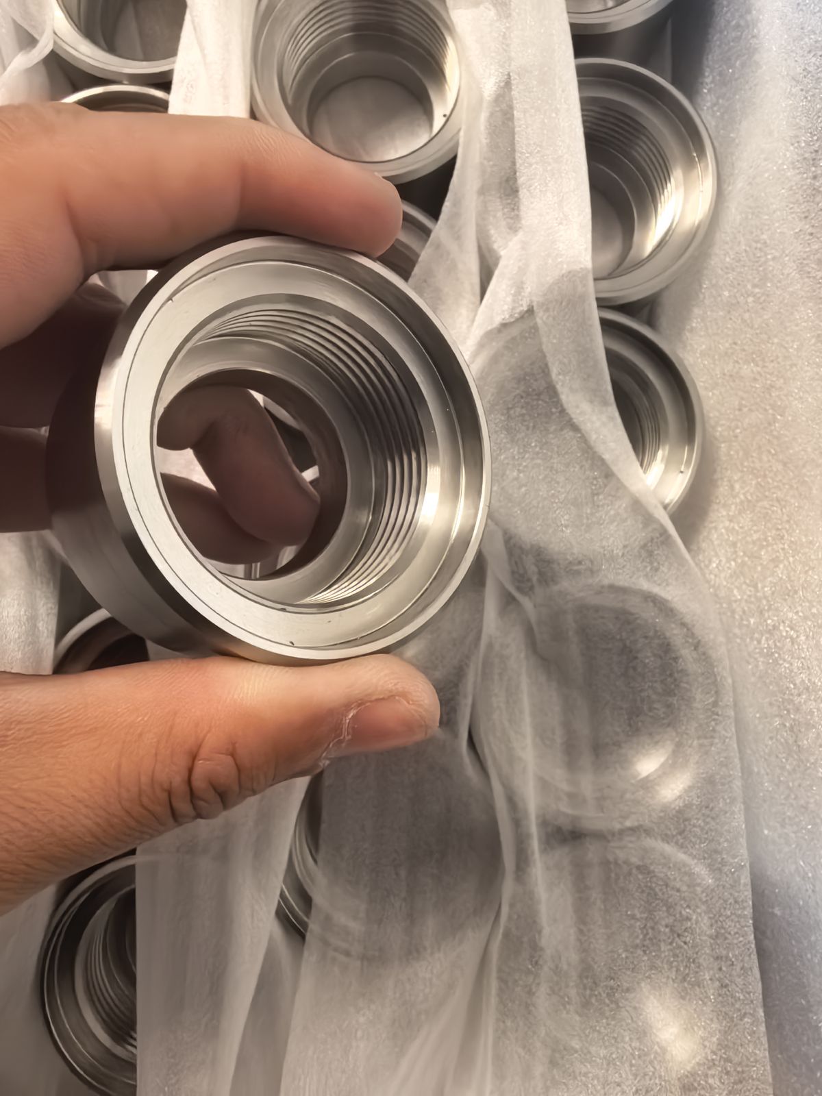 Stainless steel threaded fittings, one held in hand
